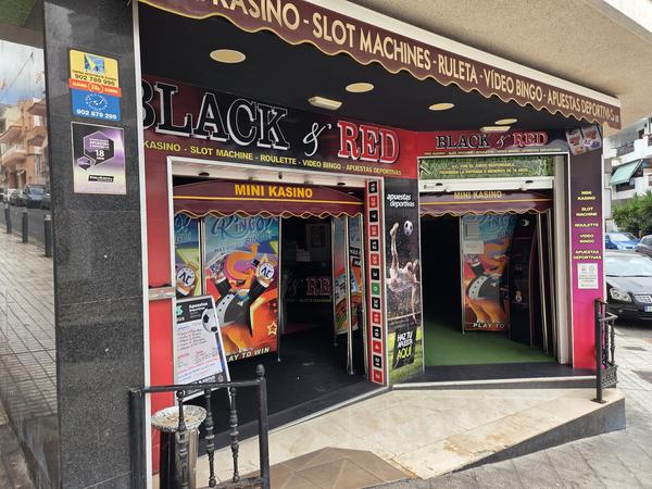 Ingresso del mini casino Black & Red ad Adeje con insegne e slot machine visibili.