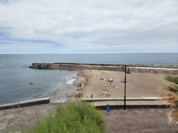 Veduta dall’alto della spiaggia di Bajamar e del frangiflutti a gradoni sul bordo del mare.