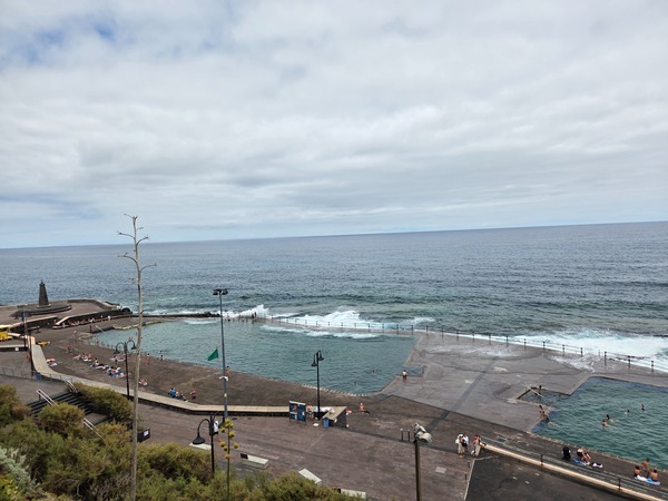 Piscine naturali di Bajamar con onde dell’oceano che entrano oltre la barriera e ampi solarium.