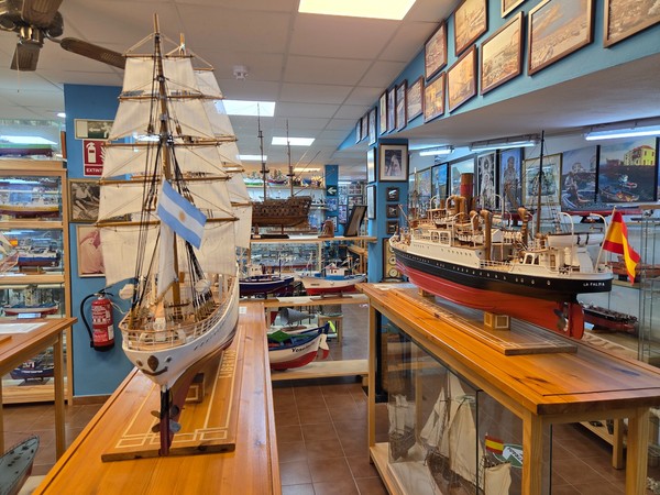 Panoramica della sala principale con grandi modelli di velieri esposti su tavoli in legno nella Casa Museo del Pescatore.