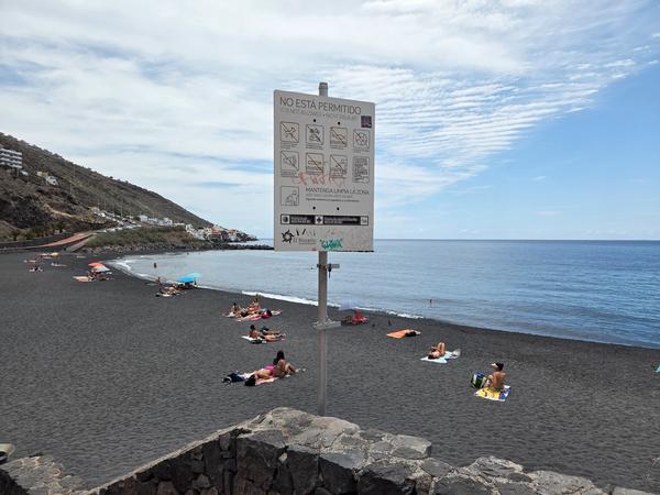 Cartello con regolamenti e simboli informativi all'ingresso della spiaggia di Nea