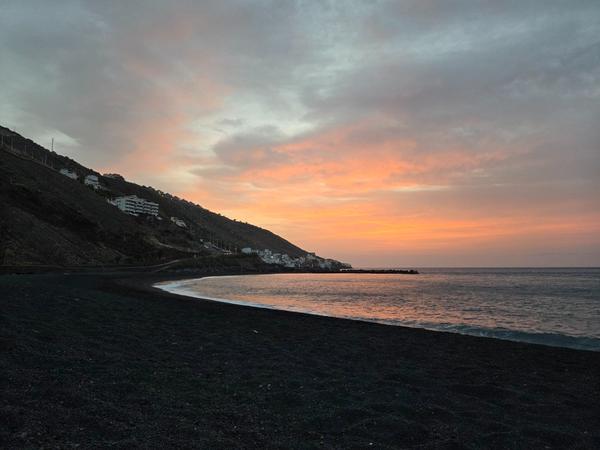 Tramonto dai colori caldi visto dalla spiaggia di Nea con il mare e le case in lontananza