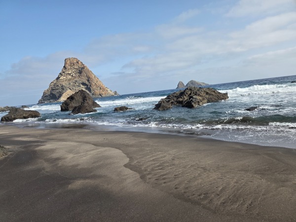 Il faraglione davanti a Playa de Las Breñas con onde dell’Atlantico e isolotti dell’Anaga sullo sfondo.
