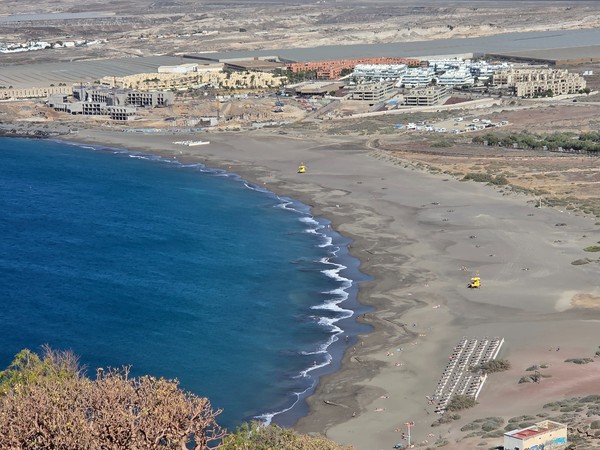 La Tejita con il profilo rosso della Montaña Roja che domina l’estremità della baia nelle ore di luce chiara.