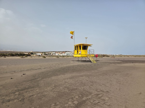 Postazione di salvataggio gialla sulla spiaggia di La Tejita con bandiere che indicano le condizioni del mare.